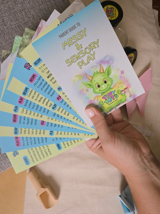 hand holding spread out set of parent guide to messy and sensory play showing part of the internal text and information