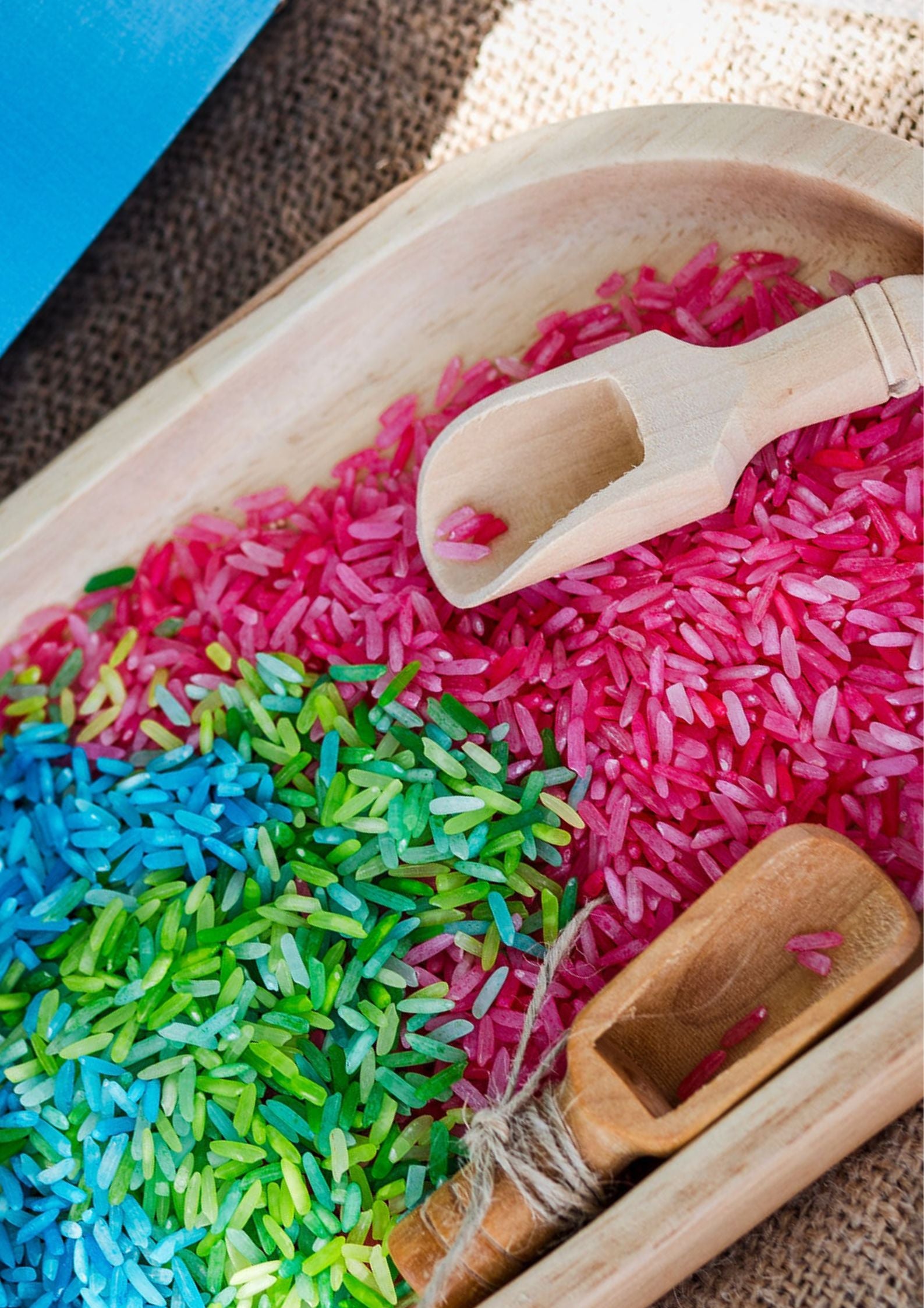 Colorful rice with wooden scoops on a wooden tray